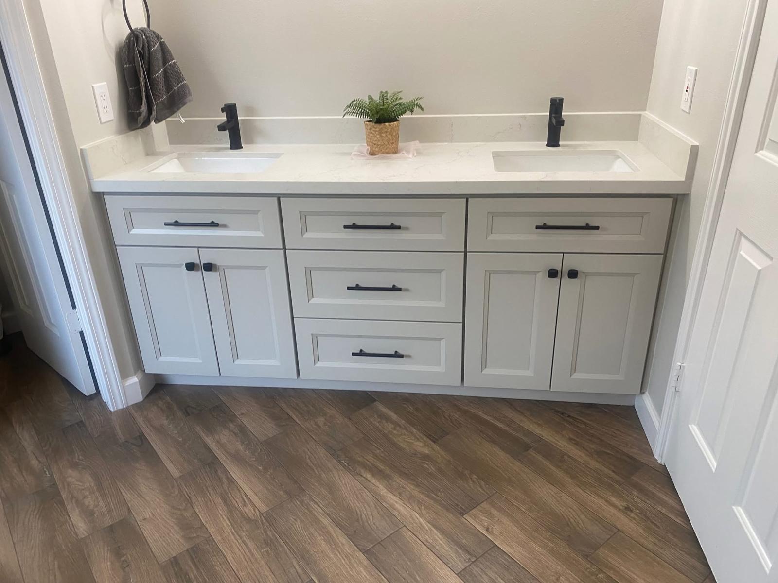 Double vanity with quartz countertop and black hardware Double vanity bathroom remodel with quartz countertops and matte black fixtures in Fort Bend County TX