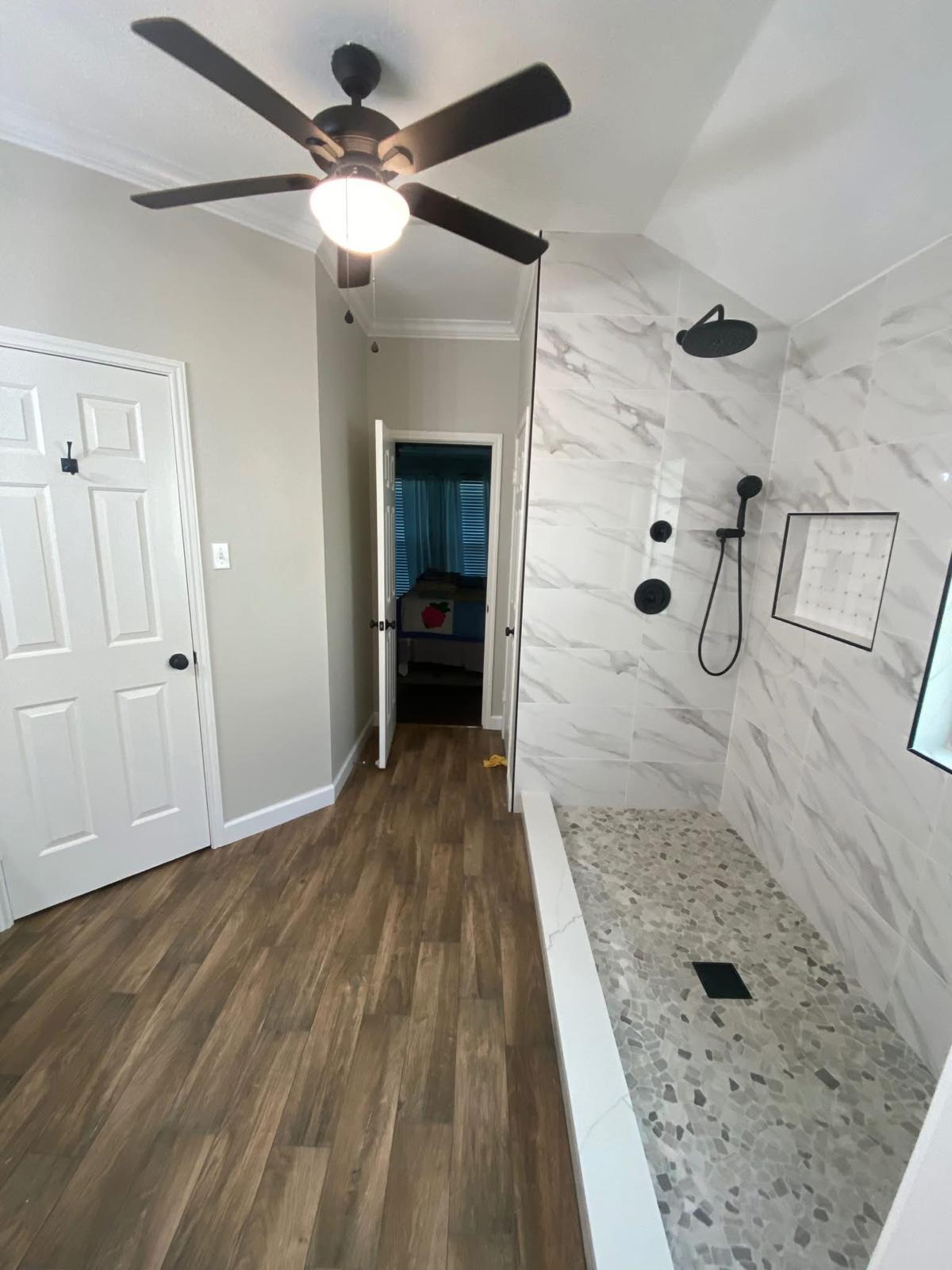 Primary bath remodel with new shower and wood-look tile Primary bathroom remodel featuring a new tiled shower and wood-look flooring in Katy TX