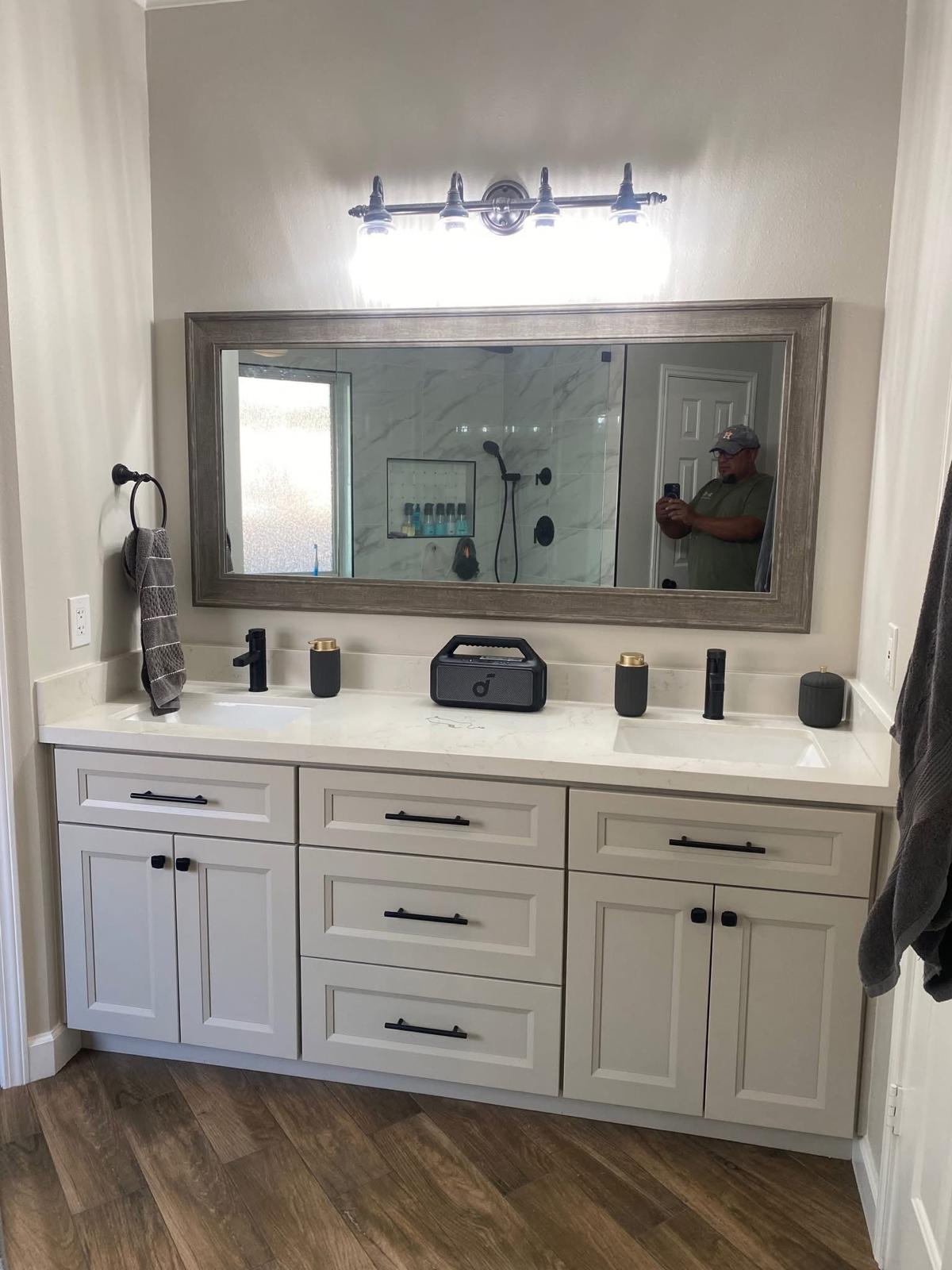 Framed mirror vanity with quartz tops and accent lighting Bathroom vanity with quartz countertop, custom lighting, and framed mirror in Fort Bend County TX